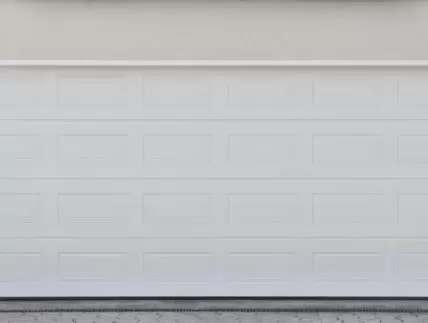 Wide white automatic garage door for two cars. Modern garage door