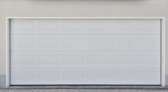 Wide white automatic garage door for two cars. Modern garage door