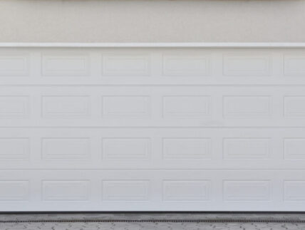 Wide white automatic garage door for two cars. Modern garage door Wide white automatic garage door for two cars. Modern garage door